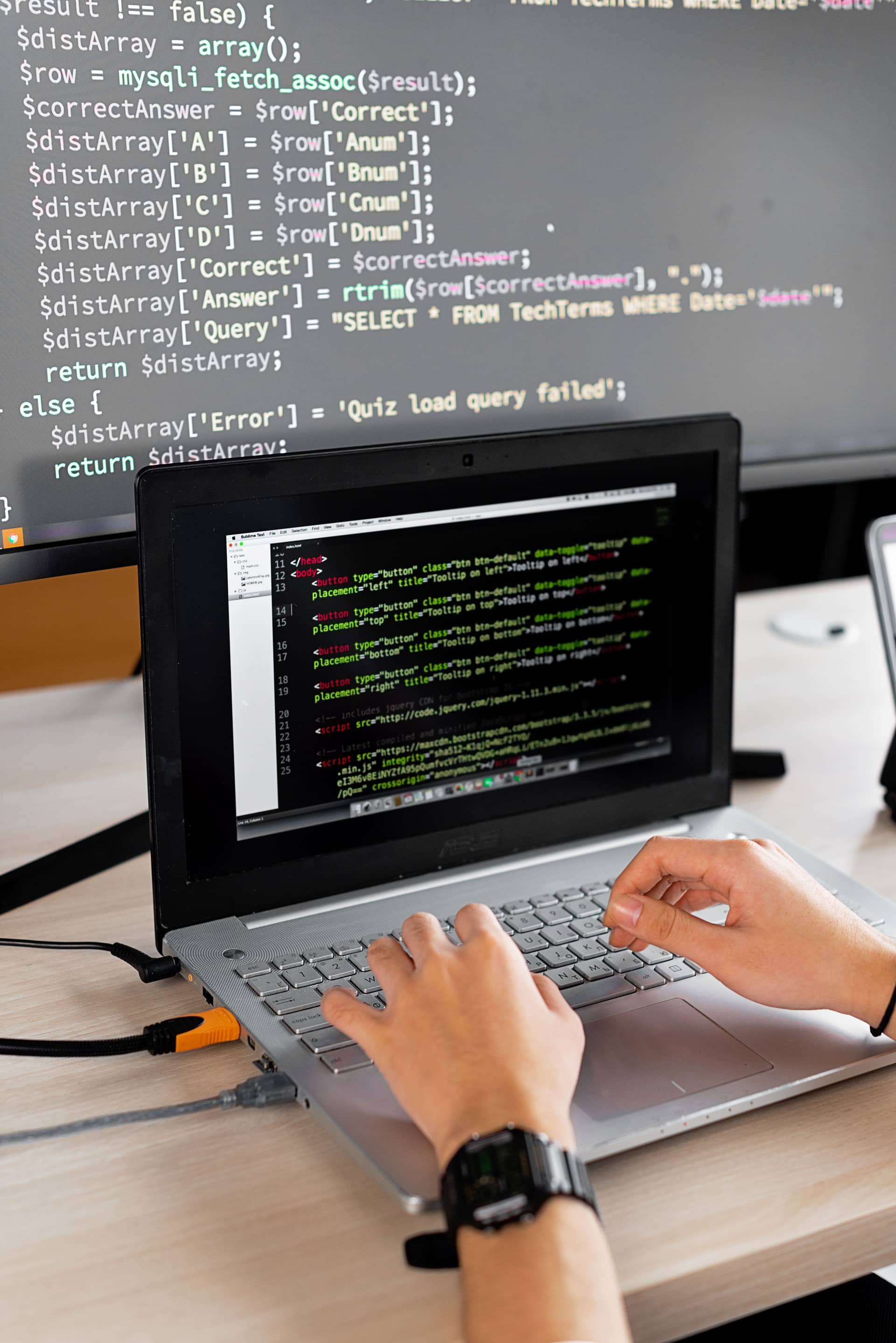Hands shipping real HTML while a PHP and SQL editor stays open