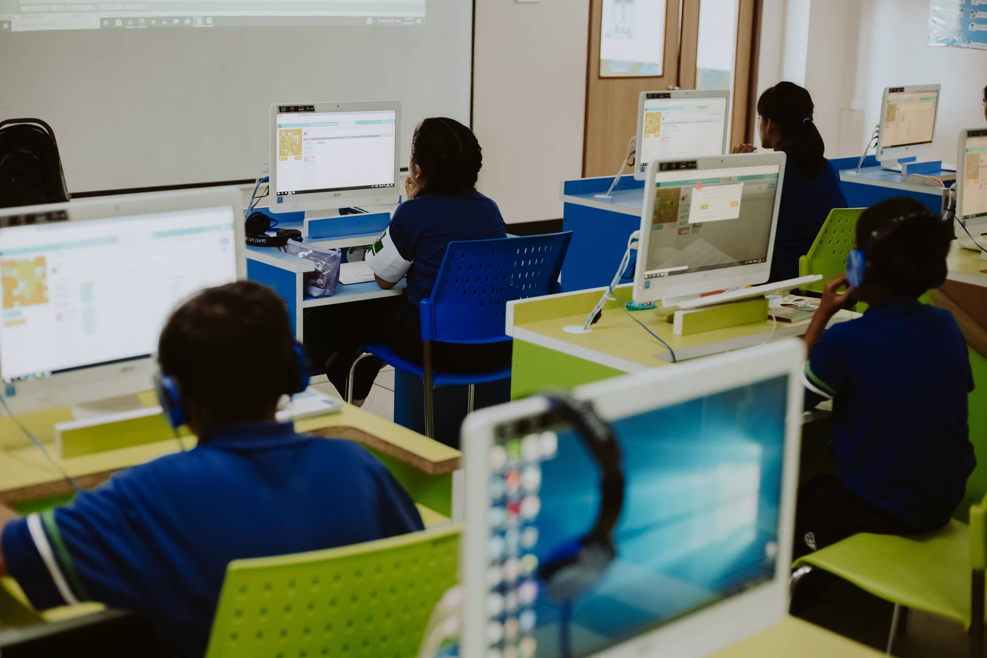 Learners focused at workstations in a bright computer lab